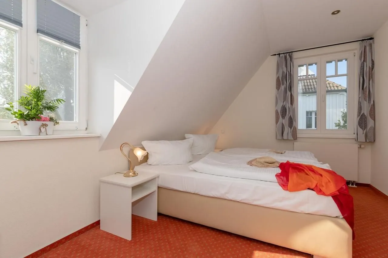 Doppelbett zwischen zwei Fenstern