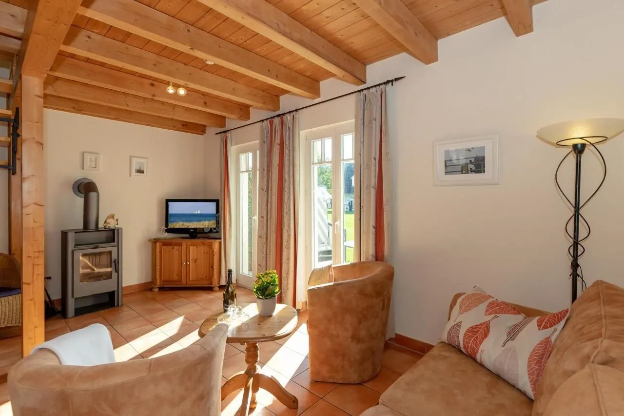 Wohnzimmer mit Kamin, Sofa und Blick in den Garten